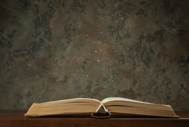 Open book on the table with dust