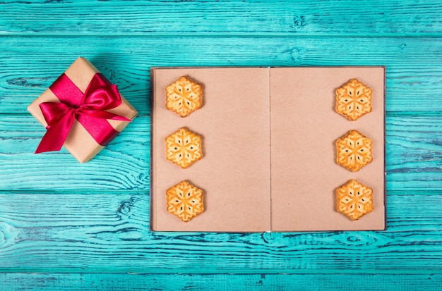 Open book with blank pages and homemade Christmas cookies