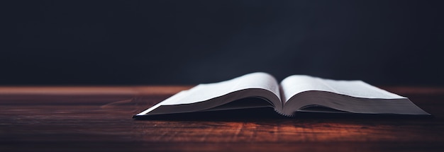 Open book on wooden desk background