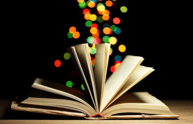 open book on wooden table on bright background
