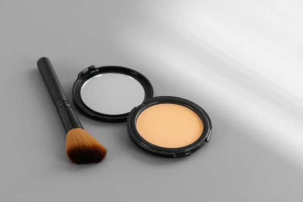 Open box with make up face powder on gray background