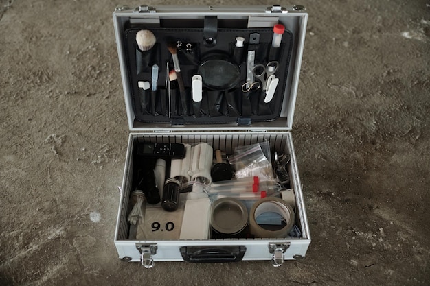 Open briefcase with variety of working supplies of crime scene investigator