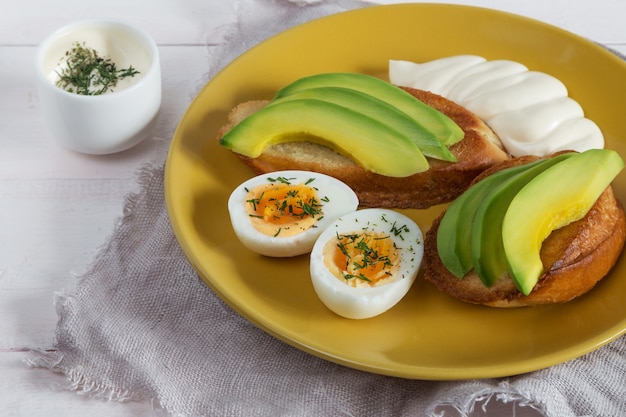 Open broodjes met avocado, eieren en saus