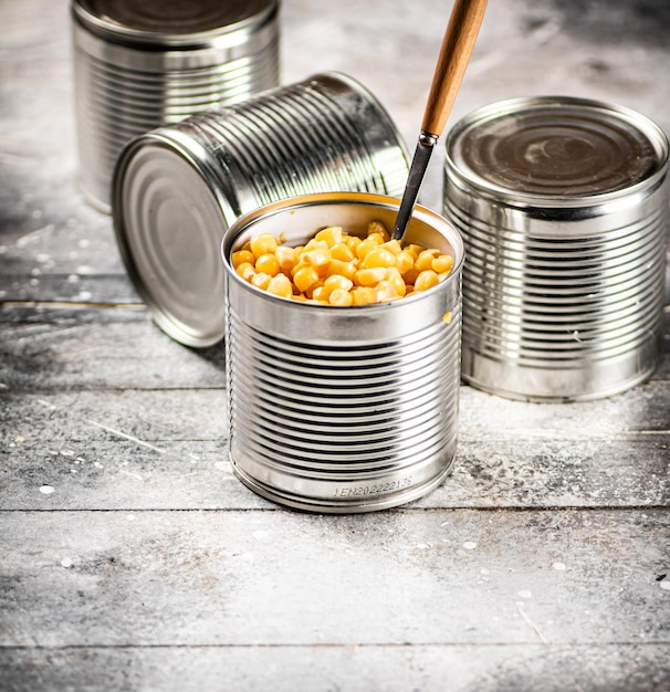 An open can of canned corn with a spoon