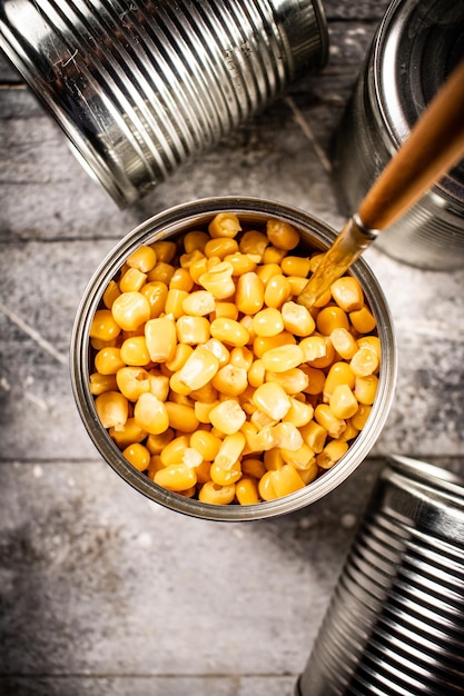 Photo an open can of canned corn with a spoon