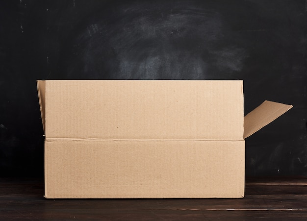 Photo open cardboard box stands on a brown table