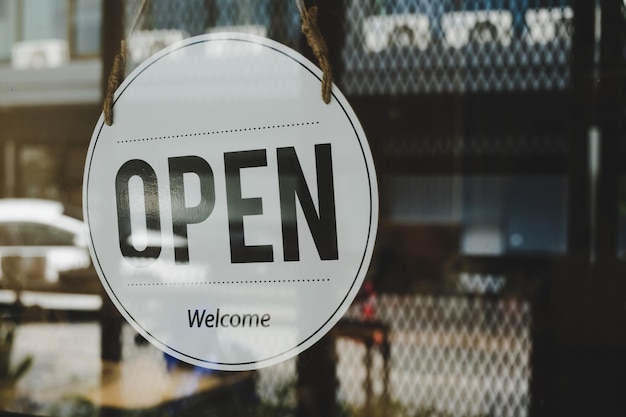 Open coffee cafe shop text on vintage sign board hanging on glass door in modern cafe shop reopen after coronavirus quarantine is over cafe restaurant small business owner food and drink concept