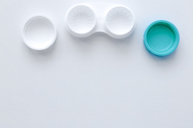 The open container for storing lenses lies on top on a white background with a place for texttop vie...