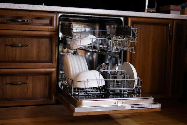 Photo open dishwasher with clean dishes in wooden surface kitchen