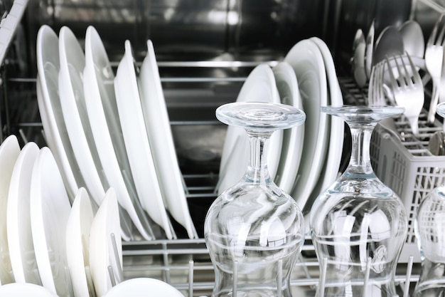 Открытая посудомоечная машина с чистой посудой.