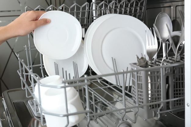 Open dishwasher with clean utensils in it