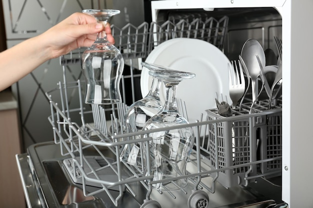 Open dishwasher with clean utensils in it