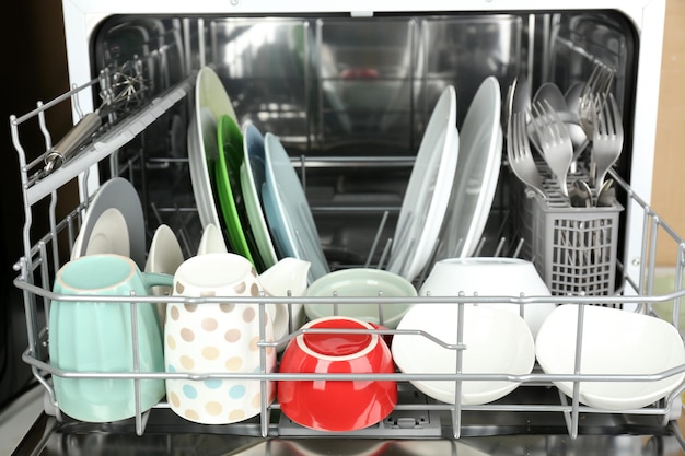 Photo open dishwasher with clean utensils in it