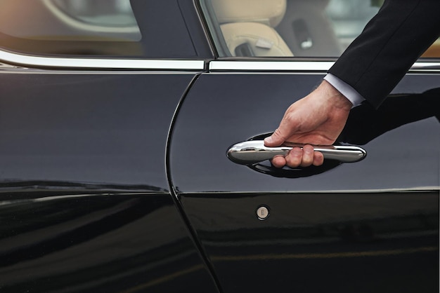 Open the door to a life of luxury Cropped shot of a well dressed man opening a car door