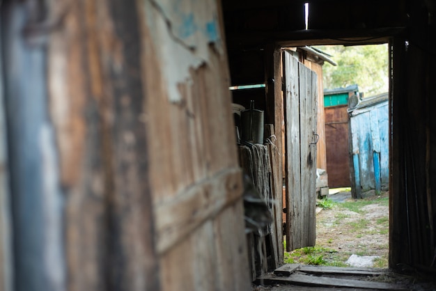 Porta aperta di un vecchio capannone in legno marcio