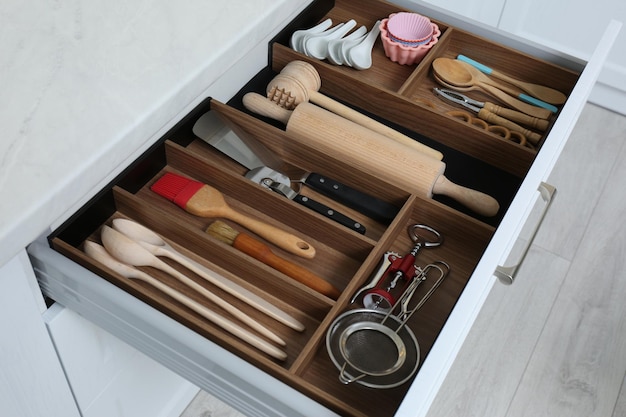 Open drawer with utensil set indoors Order in kitchen