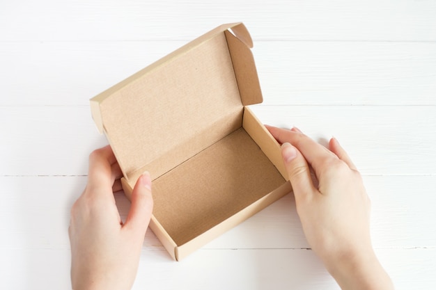 Open empty kraft box on white wooden background