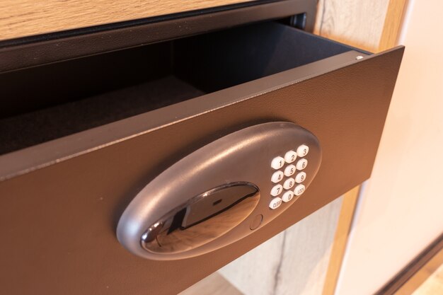 Open empty safe in hotel room or home safety box drawer with modern electronic locker and buttons