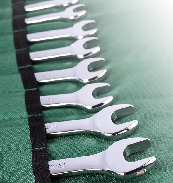 Open end wrench set on green cover on sunlight close up