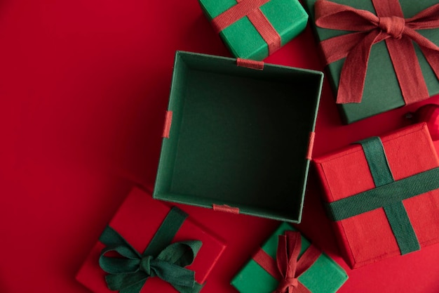 Open festive christmas present box on a red background. Flat lay, top view.