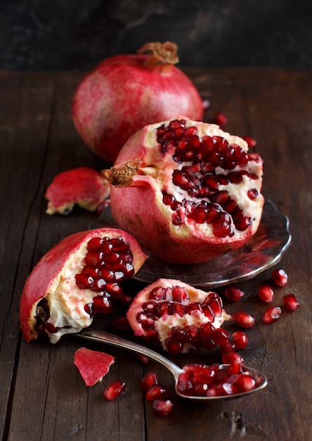 Open fresh ripe pomegranates on wooden background