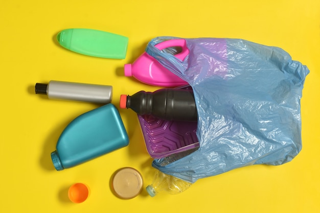 Open garbage bag with plastic bottles scattered