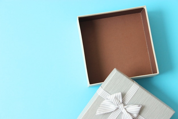 Open gift box and confetti on a colored background top view