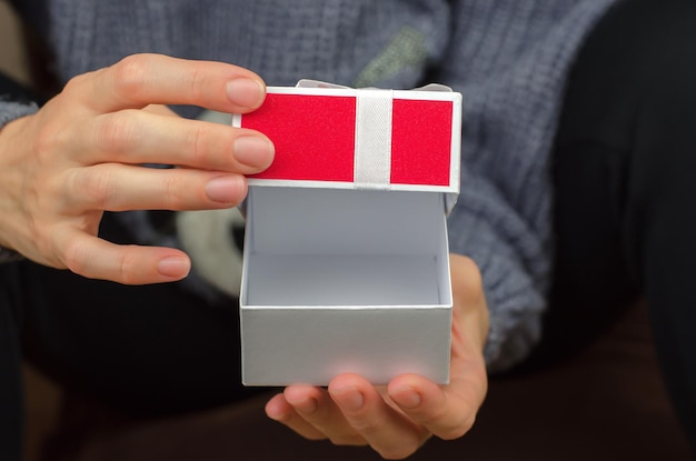 Open gift box in female hands closeup Woman opening a small gift box