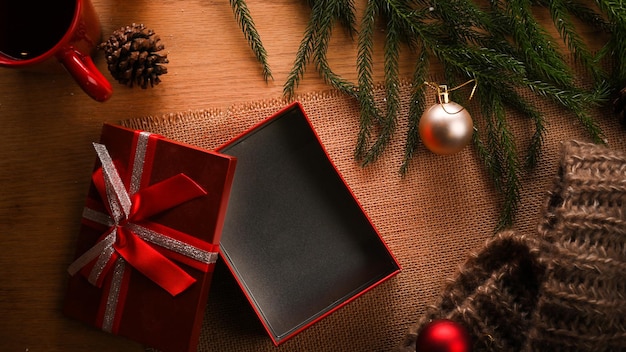 Open gift box on wooden background with Christmas decorations celebrations and holiday top view