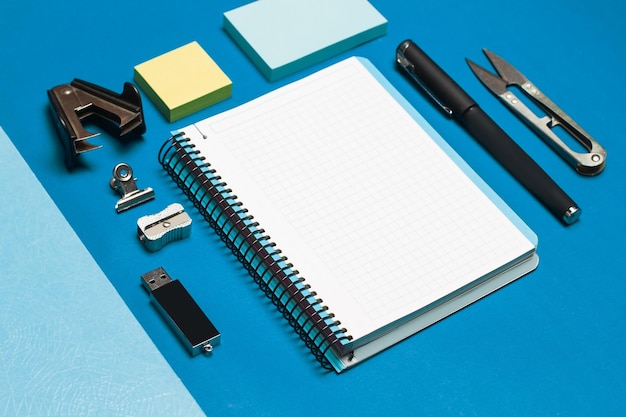 Open graph paper notebook and student utensils on a blue background