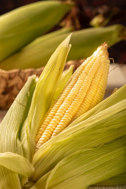 Open green corn arranged on a table with green and white tablecloth selective focus