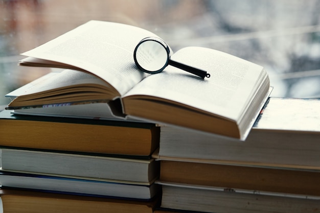 Open hardcover book, magnifying glass