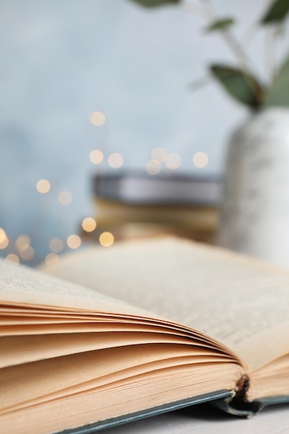 Open hardcover book on table against blurred background closeup