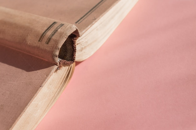 복사 공간와 분홍색 배경에 오픈 하드 커버 오래 된 책. 교육 개념