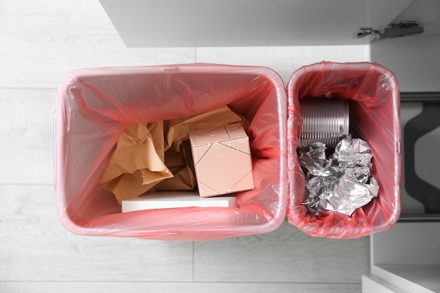 Open kast met volle prullenbakken voor gescheiden afvalinzameling in bovenaanzicht keuken