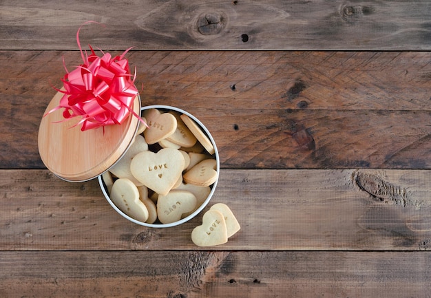 Open koekjesdoos op houten achtergrond. Ruimte kopiëren. Valentijnsdag.