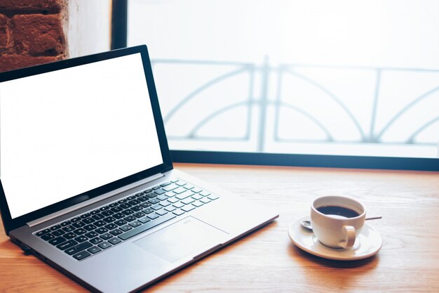 Open laptop and a Cup of coffee on the table in the cafe