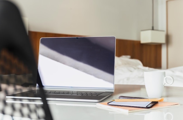 Open laptop met koffiekopje en pen op tafel