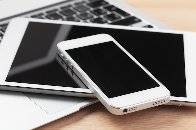 Open laptop with digital tablet and smartphone close up