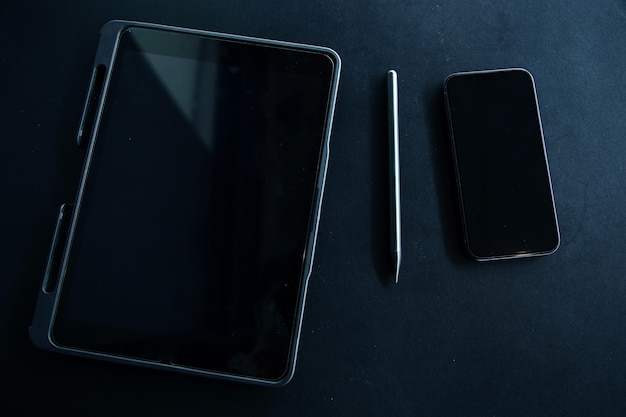 Photo open laptop with digital tablet and white smartphone all with isolated screen on old wooden desk