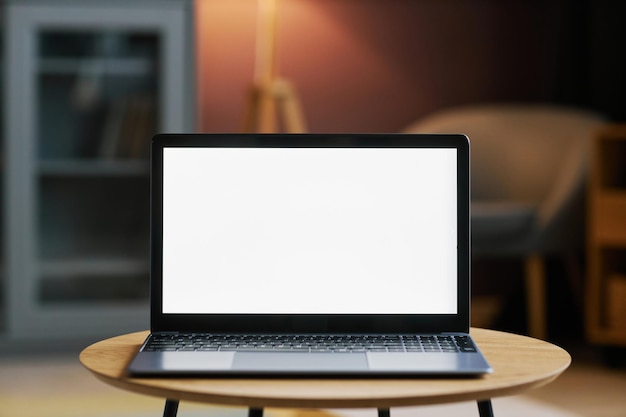 어두운 홈 인테리어에 흰색 스크린 모형이 있는 노트북 열기