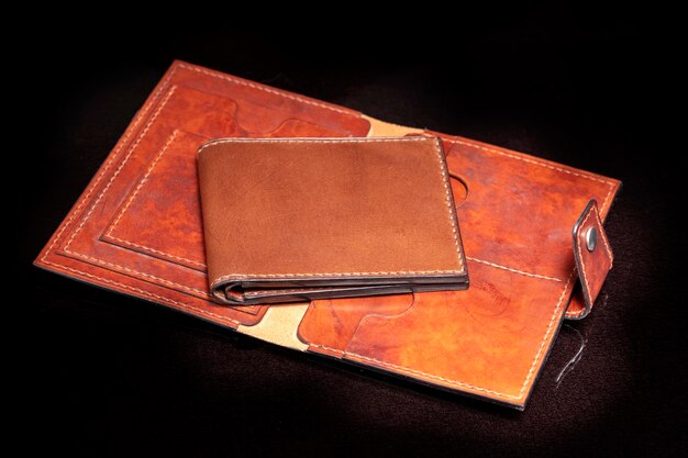写真 暗い背景にポケット付きのオープンレザーブラウンの財布。