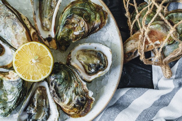 Open natte oesters op een bord met citroen