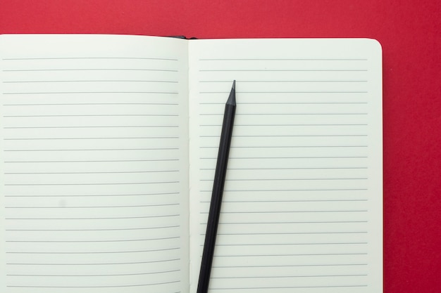 Open notebook isolated on red background, copy space for text.