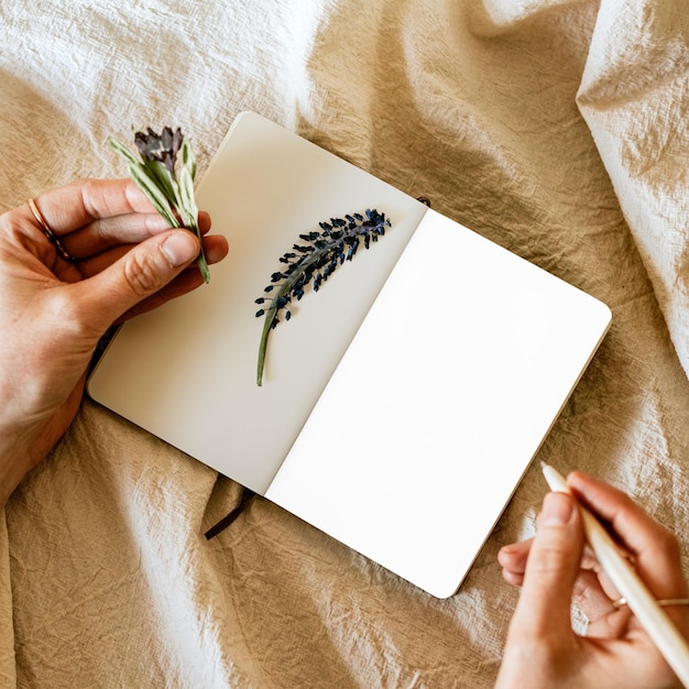 open notebook png mockup with flowers on linen blanket