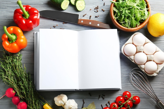 Photo open notebook and vegetables on kitchen table cooking classes concept