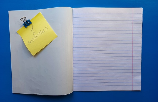 Photo open notebook on a white lining on a blue wooden tabletop.