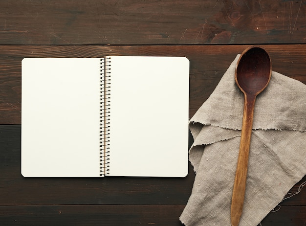 Open notebook with blank white sheets and kitchen utensils