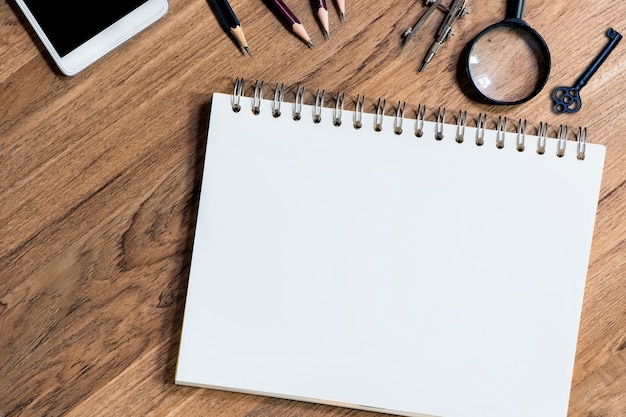 Open notebook with white blank sheets on wooden table