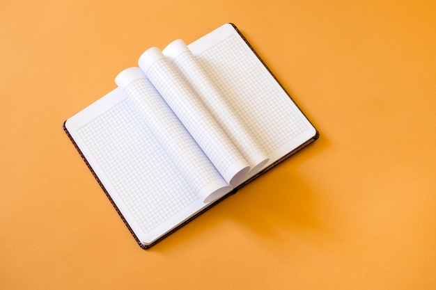 Open notebook on a yellow space, top view